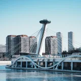 Impresionante vista de la arquitectura moderna y el perfil urbano de Tianjin, China, con cielos azules y reflejos en el río.