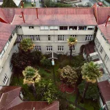 Vista aérea de un frondoso patio rodeado de edificios históricos en Valdivia, Chile.