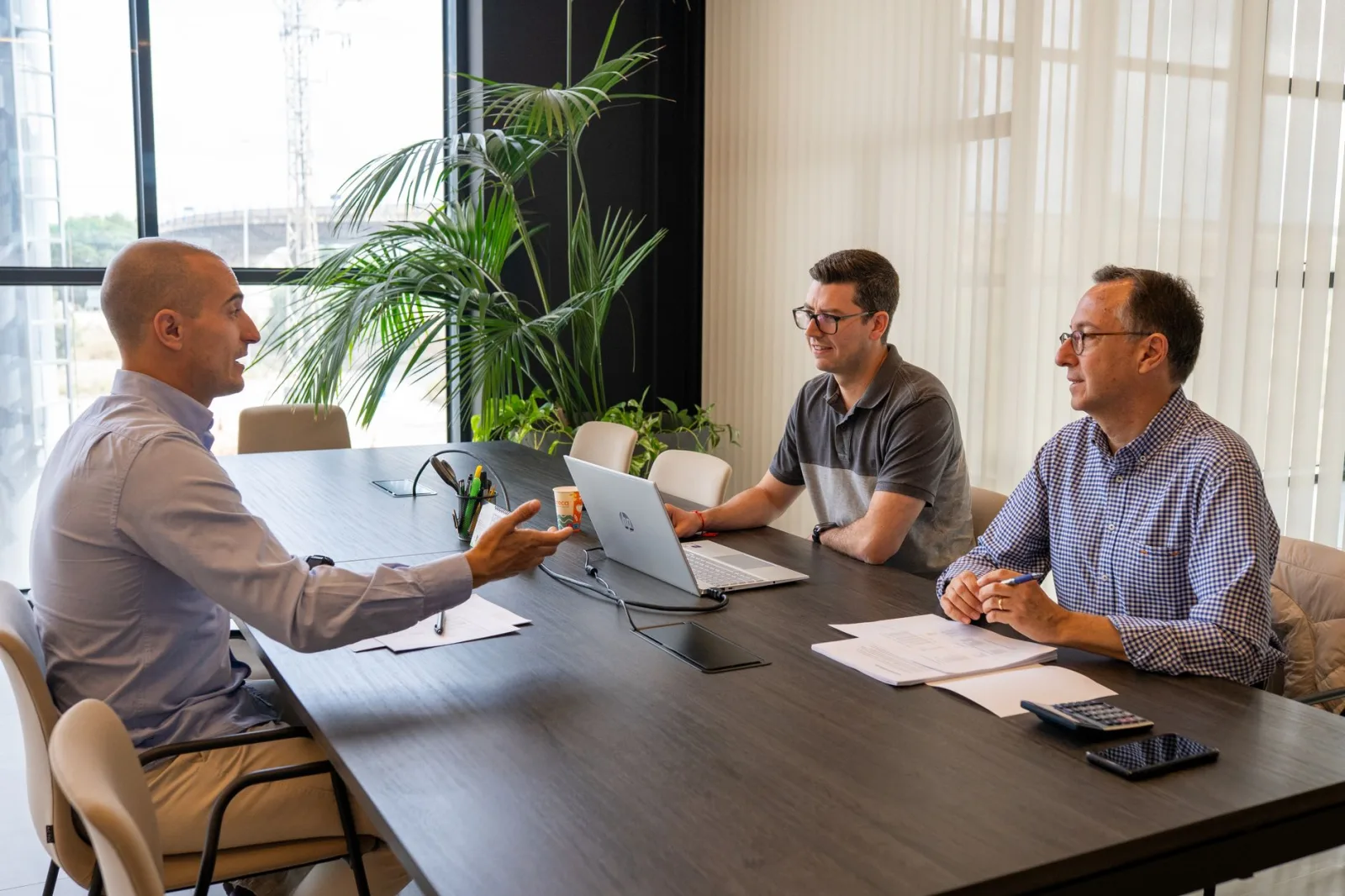 Profesionales participan en una reunión de negocios colaborativa en un entorno de oficina moderna.