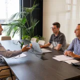 Profesionales participan en una reunión de negocios colaborativa en un entorno de oficina moderna.