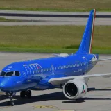 Avión azul de ITA Airways rodando por la pista del Aeropuerto Internacional de Ginebra.