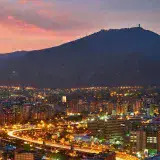 A stunning aerial view of Caracas cityscape at dusk, showcasing the vibrant city lights against the mountainous backdrop.