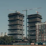 Grúas trabajando en edificios de gran altura en Buenos Aires, capturadas bajo un cielo despejado.