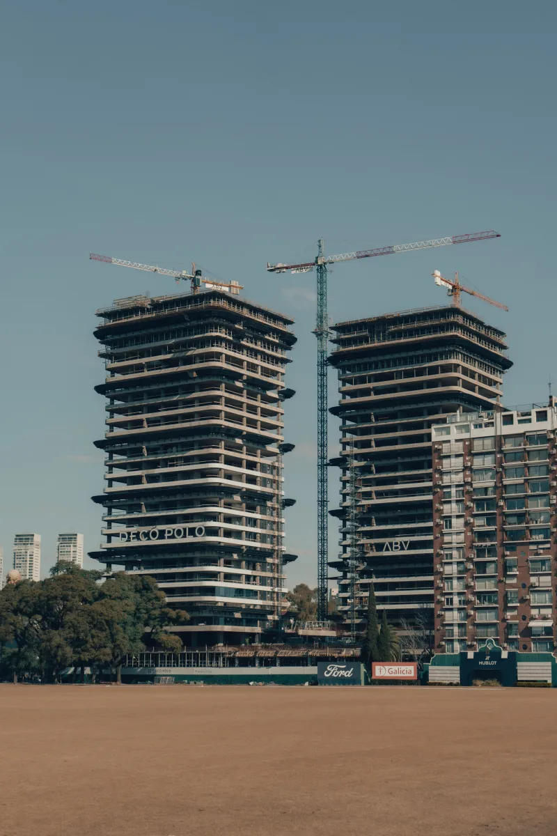 Grúas trabajando en edificios de gran altura en Buenos Aires, capturadas bajo un cielo despejado.