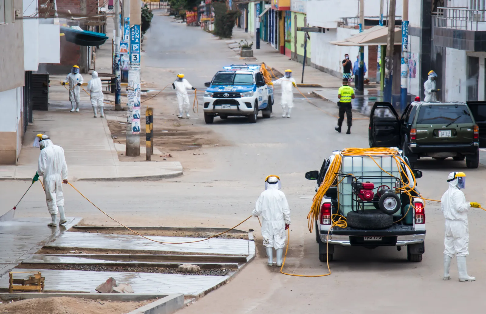 Trabajadores con equipo de protección sanitizan las calles de Chorrillos, Lima, para frenar la propagación del COVID-19.