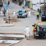 Trabajadores con equipo de protección sanitizan las calles de Chorrillos, Lima, para frenar la propagación del COVID-19.