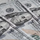 Vista de cerca de varios billetes de cien dólares estadounidenses con el retrato de Benjamin Franklin.