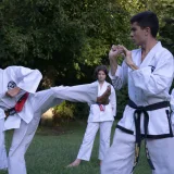 Adolescentes practicando artes marciales en un parque de Buenos Aires, demostrando concentración y disciplina.
