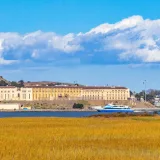 Vista de la prisión de San Quentin al otro lado del agua, con un transbordador y nubes dramáticas.