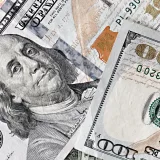 Primer plano detallado de varios billetes estadounidenses de cien dólares en una disposición dispersa.