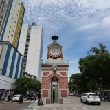 Historic clock tower Relógio Municipal amidst cityscape in Manaus, Brazil.