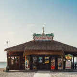 Beach hut at De Palm Pier in Aruba with clear skies and sparkling ocean.